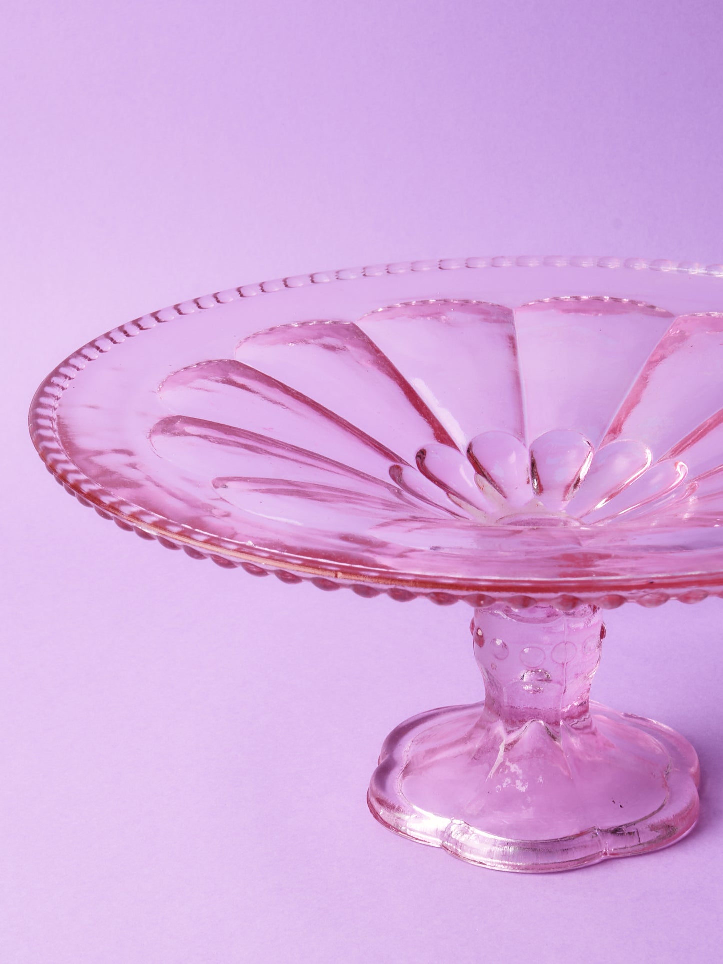 Pink glass cake stand with petal motif