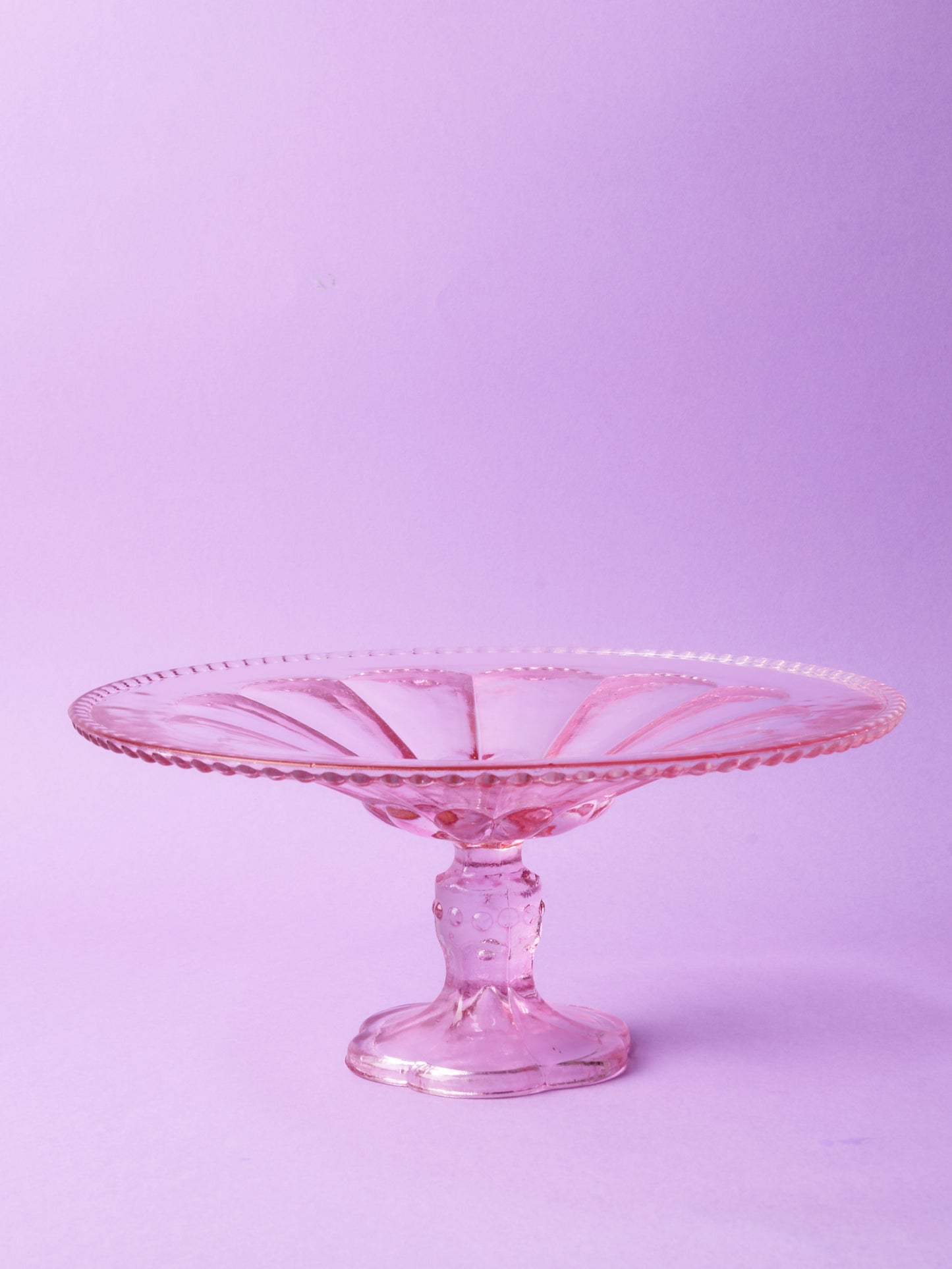 Pink glass cake stand with petal motif