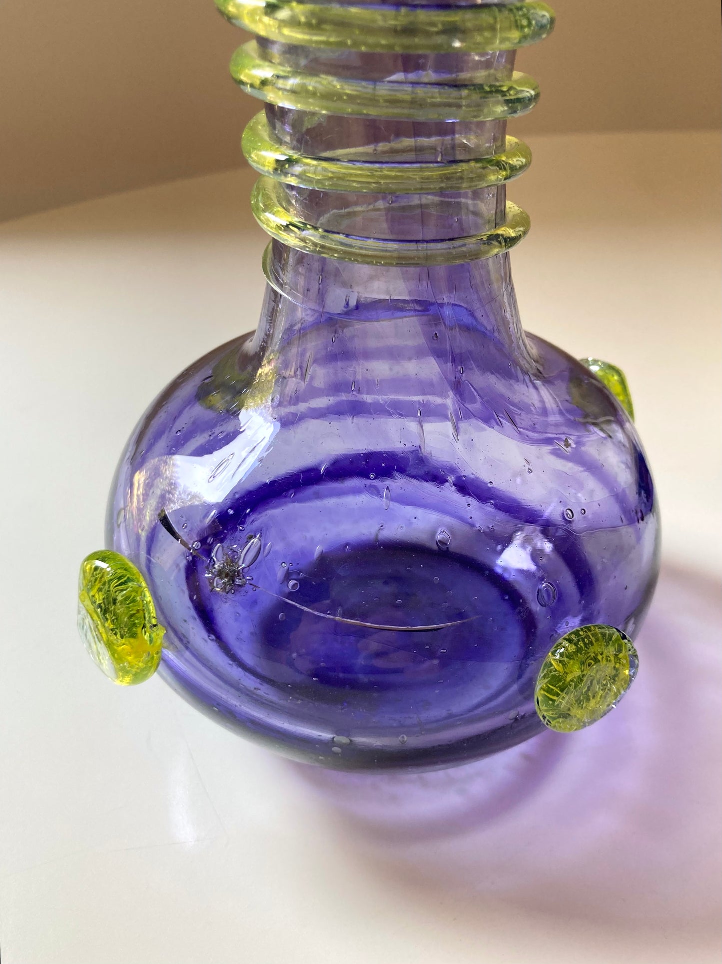 Vintage purple glass vase with green decorations